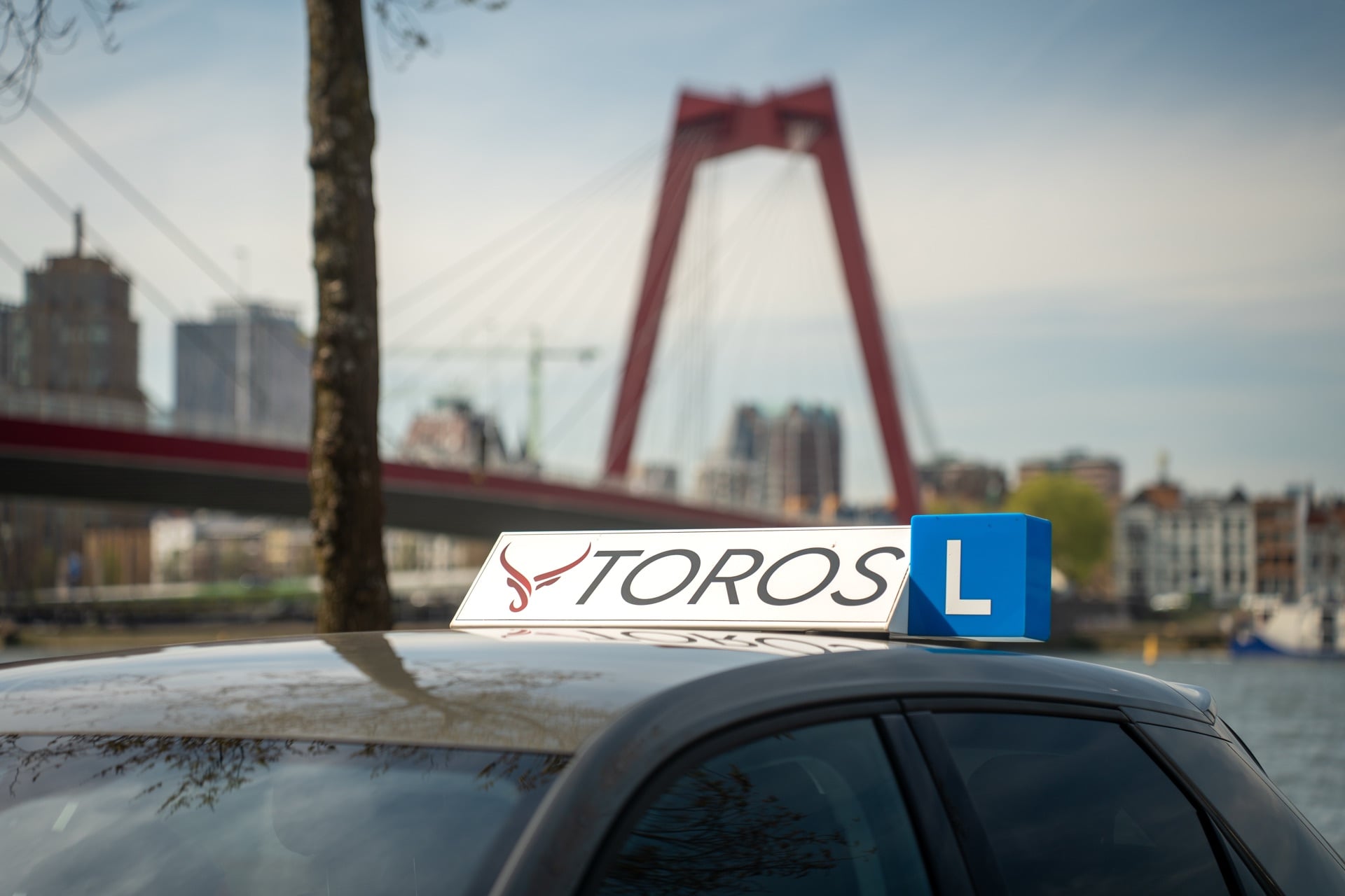 Rijschool Toros lesauto bij de Willemsbrug in Rotterdam