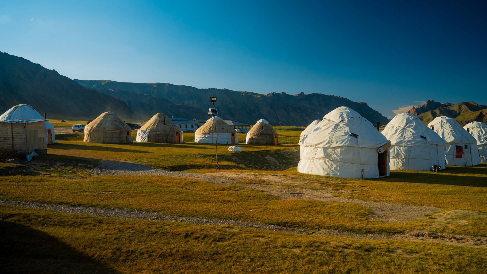 Yurts in een bergvallei in Kirgizië tijdens het gouden uur